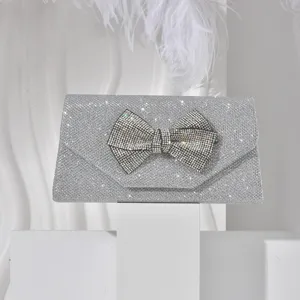 Sparkling silver rhinestone bow evening bag detail, luxurious glitter clutch for women.