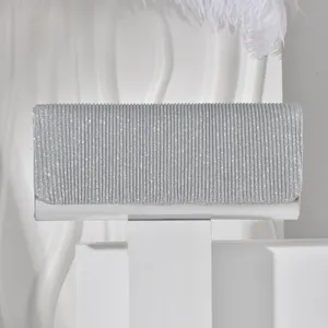 Detailed view of a silver glitter clutch bag, featuring fine shimmer texture for formal evening events.