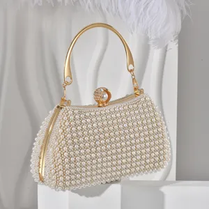 Elegant pearl evening clutch bag with gold metal handle and sparkling rhinestone clasp detail.