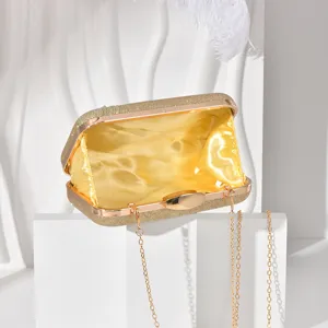 Detail view of a glamorous gold glitter evening clutch bag with bright yellow satin lining.