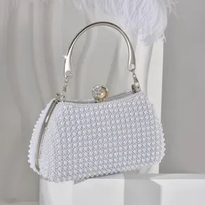 Elegant pearl evening bag detail, sparkling rhinestone clasp and metallic handle, fine texture.