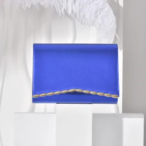 Blue envelope evening clutch bag with elegant gold scalloped metal trim detail surface.