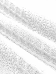 Close-up view of premium white textured fabric detail showing intricate weave pattern clearly.