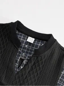 Detail shot of the black textured long sleeve top collar with plaid lining and size tag.
