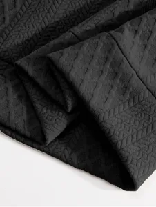 Black men's sweatshirt fabric detail, showing premium textured geometric pattern close-up.