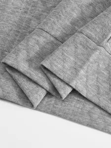 Close-up detail of grey men's hoodie fabric, showing soft texture and neat folds.