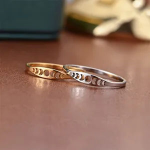 Primer plano detallado de anillos de metal de fase lunar minimalista en oro y plata.