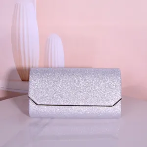 Silver glitter evening clutch bag detail showing sparkling texture and metallic frame edge.