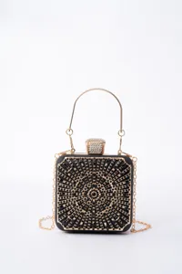 Detail shot of the sparkling rhinestone evening clutch, highlighting intricate geometric metal design.