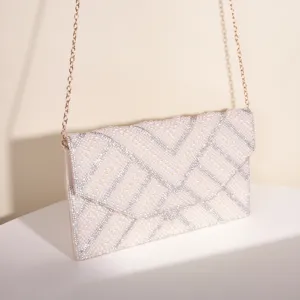 Elegant pearl rhinestone envelope evening bag detail, sparkling crystal embellishment close up.