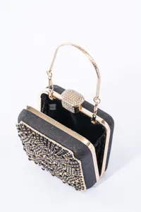 Detail view of a black rhinestone evening clutch bag with gold frame and intricate crystals.