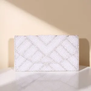 Detailed view of an elegant pearl and rhinestone embellished evening envelope clutch bag.