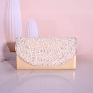 Champagne gold evening clutch bag detail featuring delicate pearl and rhinestone embellishments.