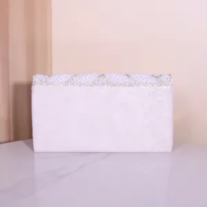 Detailed view of elegant white evening clutch with sparkling pearls and rhinestone design.