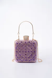 Detail view of a stunning purple crystal evening clutch bag with gold handle and chain strap.