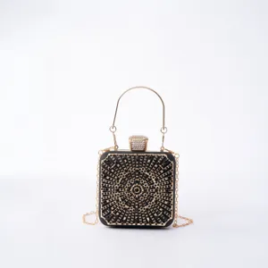 Black rhinestone evening clutch bag with metal handle and chain strap for luxury party.
