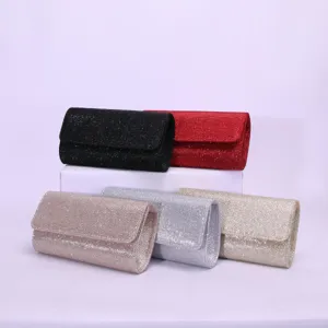 Glitter evening clutch bag detail showing sparkling fabric and elegant magnetic flap closure design.