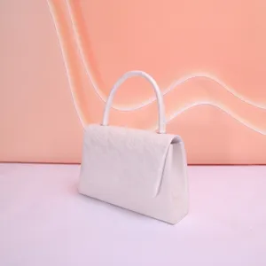 Gros plan détaillé de la texture en dentelle blanche élégante sur un sac à main de soirée.