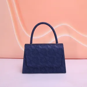Détail de sac à main en dentelle exquis, sac de soirée bleu foncé avec poignée et rabat.