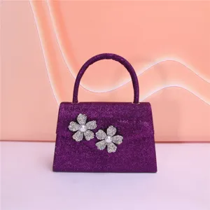 Detailed shot of the sparkling purple evening bag with stunning rhinestone flower decor close up.
