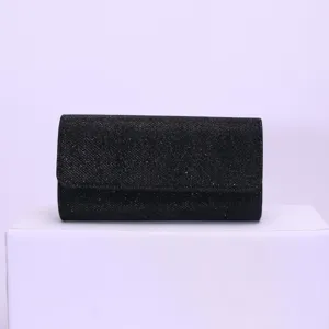 Details of black glitter evening clutch bag, elegant accessory showing fine sparkling texture.