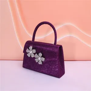 Purple glitter evening bag detail with rhinestone pearl flower embellishments and top handle.