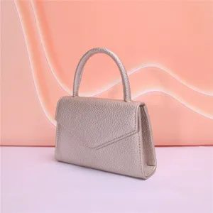 Chic borsa da sera color oro champagne con manico e design a patta a busta elegante.