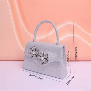Silver glitter evening handbag detail with rhinestone flower and pearl decor. 8.07 inch
