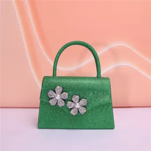 Green sparkly evening bag detail showcasing the exquisite rhinestone pearl flower decoration.