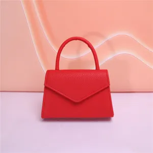 Dettaglio borsa da sera in pelle rossa, manico strutturato e design con patta elegante.