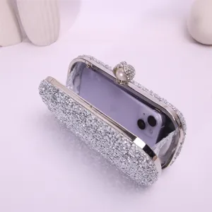 Detailed view of the sparkling rhinestone evening clutch bag open with a phone inside for capacity.