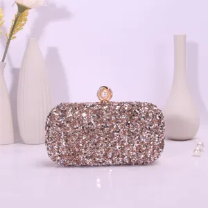 Detailed view of the sparkling sequin evening clutch bag with elegant pearl clasp and glittering rhinestones.