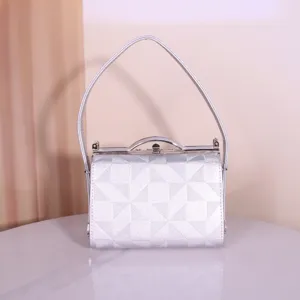 Vue détaillée du sac de soirée argenté à motif géométrique avec cadre métallique et poignée.