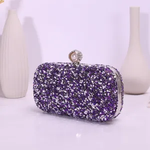 Close-up view of the sparkling purple rhinestone evening clutch bag with pearl clasp detail.