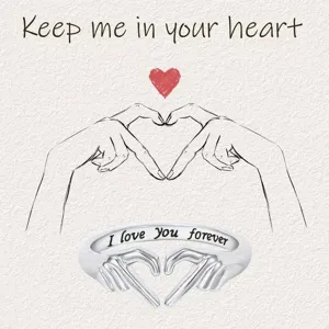 Vista de detalle en primer plano del anillo de plata con gesto de corazón y texto grabado.