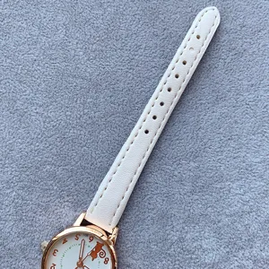 Details of women quartz watch with white leather strap and cute kitten dial design.