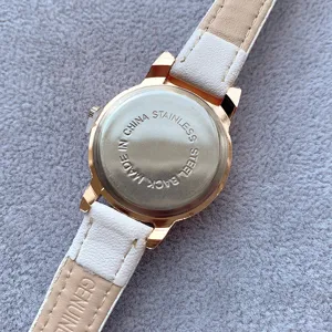 Detailed close-up view of the stainless steel watch back and white leather strap.