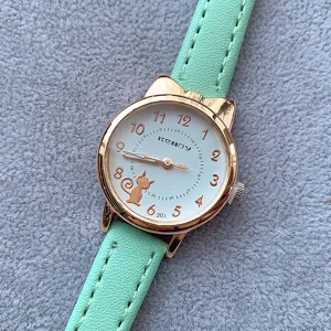 Cute cat design student quartz watch with mint green leather strap and clear dial details.