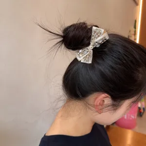 Sparkling rhinestone bow hair tie detail, elegant champagne crystal hair accessory for buns.