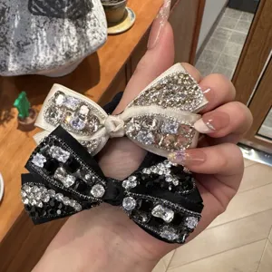 Detail closeup of sparkling rhinestone and black diamond bow hair ties, elegant hair accessories.