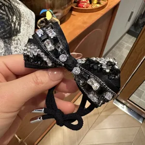 Black rhinestone bow hair tie detail, sparkling crystal and gem design for elegant updos.