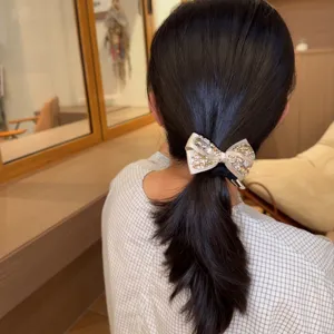 Champagne rhinestone bow hair tie detail view, sparkling crystal hair accessory for elegant styling