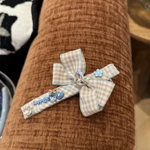 Korean plaid bow hair clip detail shot, featuring rhinestone heart and cute blue flower accents.
