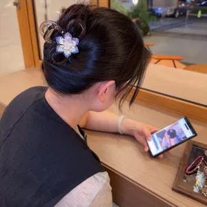 Vista dettagliata di un elegante morsetto per capelli medio con strass colorati, forcina chic.