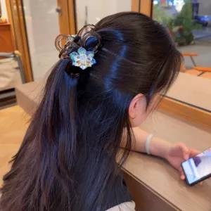 Dettaglio molletta per capelli con fiori di strass, elegante accessorio semi-raccolto.