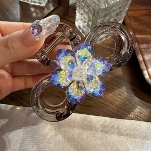 Primo piano dettagliato di molletta per capelli in resina scura con fiore in strass e molla.