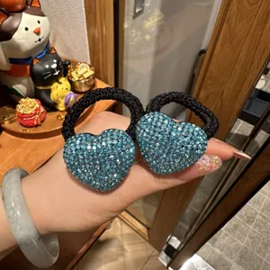 Sparkling blue rhinestone heart hair tie detail close-up, elegant elastic pony tail holder.