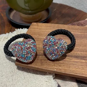 Sparkling rhinestone heart hair tie detail, chic black braided ponytail holder fashion accessory.