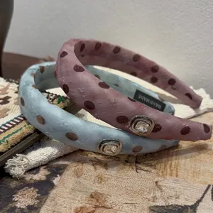 Gedetailleerd uitzicht op schattige stippen haarbanden met strass stenen voor dames.