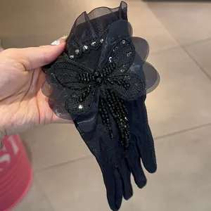 Gants courts en dentelle noire avec glands de papillon perlés, protection solaire élégante.